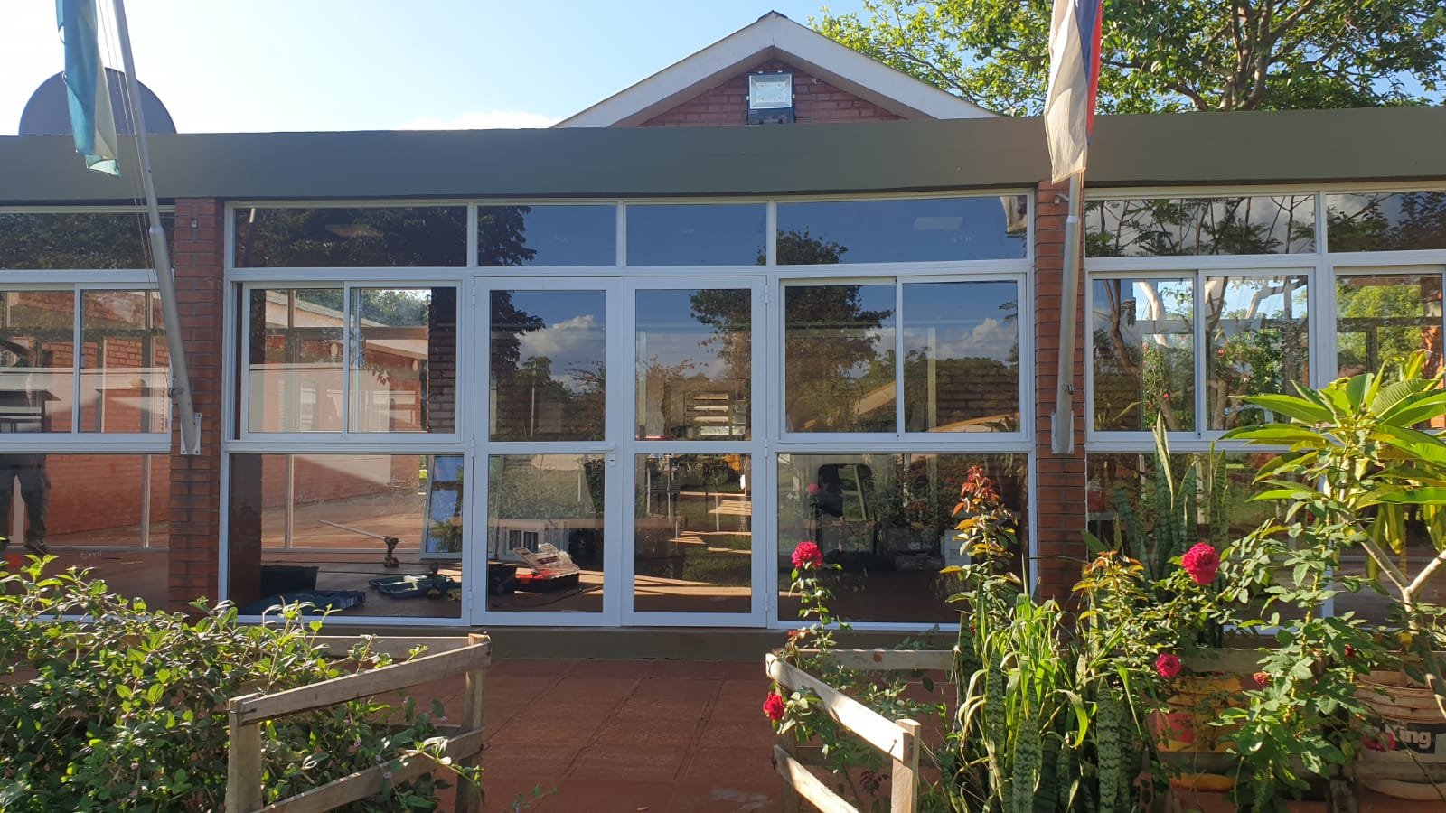 Galería cerrada con estructura de aluminio blanco y vidrio